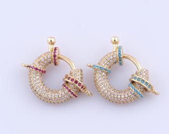 May include: Two gold-tone toggle clasps with a round design. Both clasps are covered in clear rhinestones and have a band of colored rhinestones. One clasp has a band of red rhinestones and the other has a band of blue rhinestones.