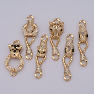 Puede incluir: Seis abalorios de metal dorado con diseños de animales. Cada abalorio tiene un bucle en la parte superior para sujetarlo a una pulsera o collar. Los abalorios representan una serpiente, un leopardo y un jaguar. Los abalorios están decorados con diamantes de imitación transparentes y negros.
