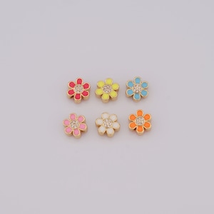 Puede incluir: Seis abalorios de flores de tono dorado con esmalte y diamantes de imitación transparentes. Los abalorios son de color rosa, amarillo, azul claro, blanco y naranja.