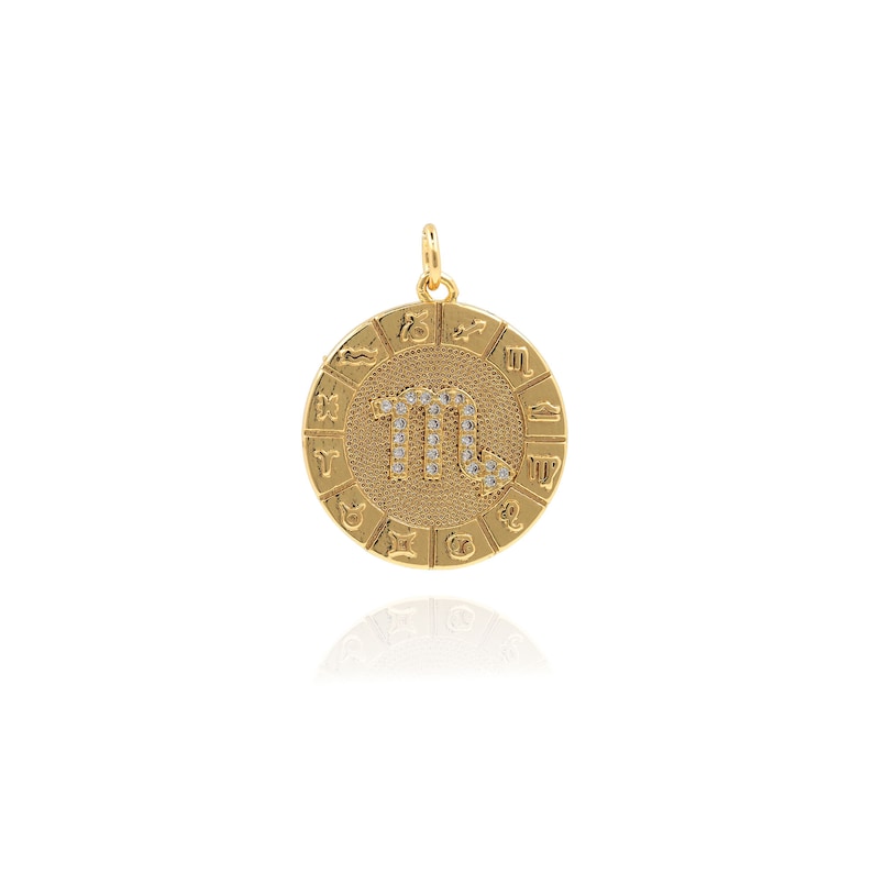 May include: Gold zodiac pendant featuring the Scorpio constellation with sparkling rhinestones. The pendant is surrounded by a circle of zodiac signs.