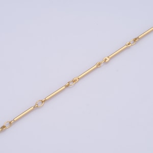 May include: A gold chain necklace with a simple, straight bar design. The chain is made of small, linked bars.