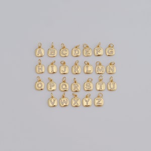 Puede incluir: Un conjunto de 26 abalorios de letras del alfabeto de color dorado, cada letra está incrustada con diamantes de imitación transparentes. Los abalorios son de forma cuadrada y tienen un bucle en la parte superior para sujetarlos a un collar o pulsera.