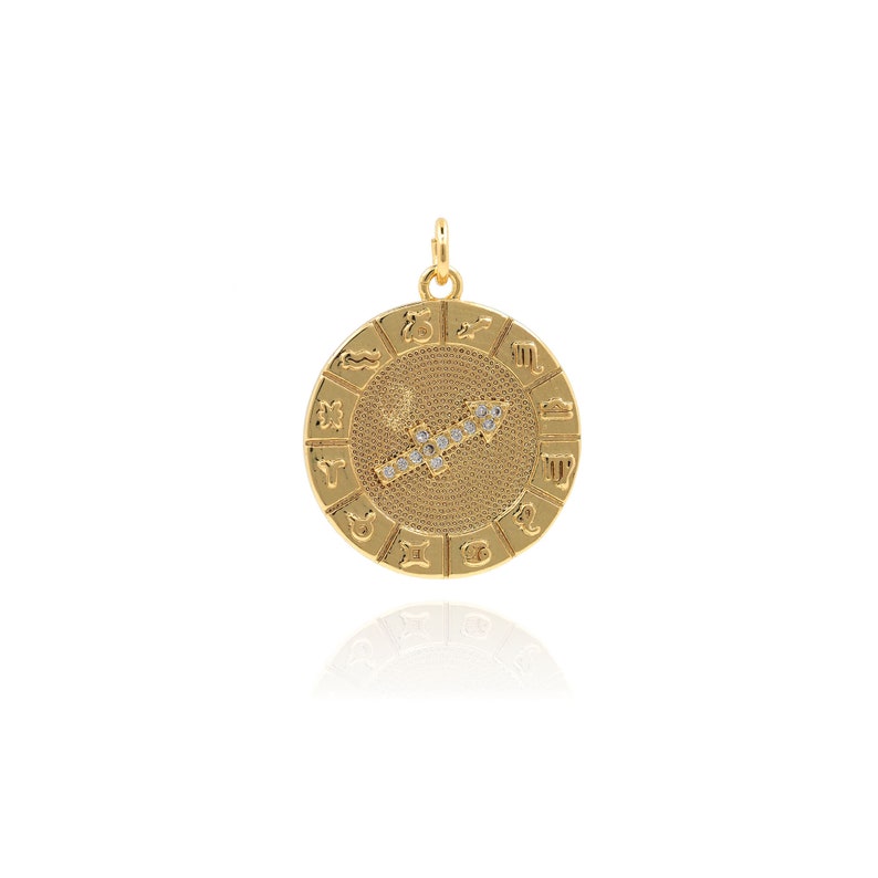 May include: Gold zodiac pendant featuring the Sagittarius constellation with clear crystals. The pendant is round and has all 12 zodiac signs around the edge.