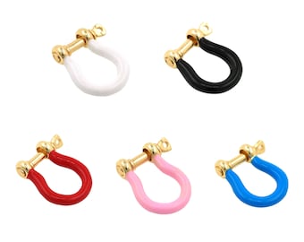 May include: Five colorful U-shaped jewelry charms. Each charm features a gold-colored metal base with a screw closure and a U-shaped enamel section in white, black, red, pink, and blue. These charms are suitable for jewelry making.