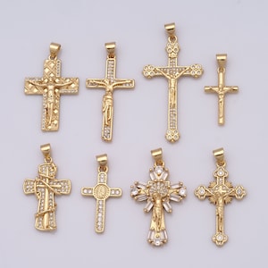 Puede incluir: Ocho colgantes de cruz de tono dorado con acentos de cristal transparente. Las cruces presentan varios diseños, incluyendo una cruz simple, una cruz con una figura de Jesús y una cruz con un diseño floral.