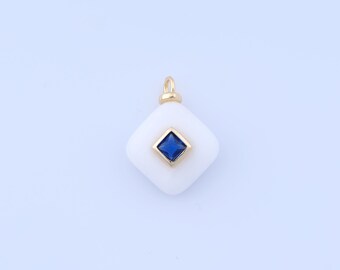 May include: A white, square pendant with a gold-coloured bail and a gold-framed, square, dark blue gemstone at its centre. The pendant has rounded corners and a smooth surface. Jewellery.