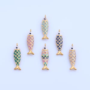 以下が含まれることがあります： 金色のアクセントが付いた、7つのカラフルな魚の形をしたペンダント。各ペンダントは、緑、青、ピンク、および色の混合など、さまざまな配色が特徴です。ペンダントの上部には、吊り下げ用の小さなループが付いています。