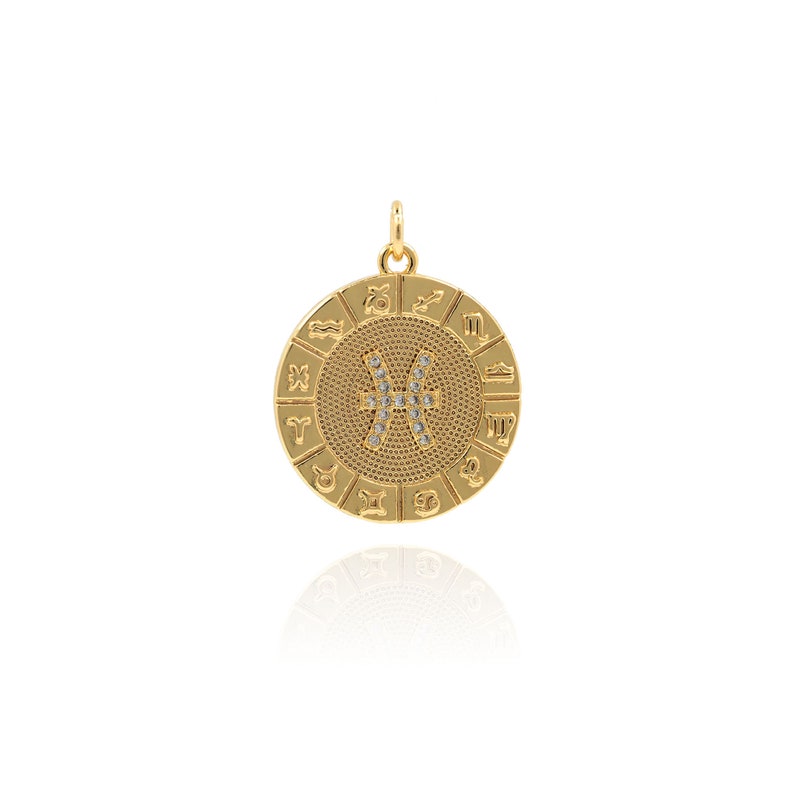 May include: Gold zodiac pendant with a circle of zodiac signs and a Pisces symbol in the center, set with clear crystals.