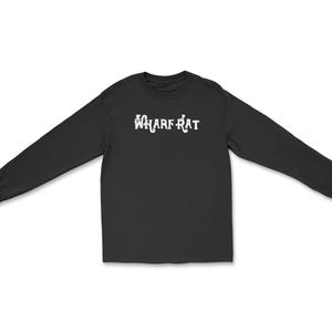 May include: Black long-sleeve shirt with the white text "WHARF RAT" across the chest. The shirt is made of a soft material and has a crew neck. The sleeves are long and end in a ribbed cuff. The shirt is spread out on a white background.