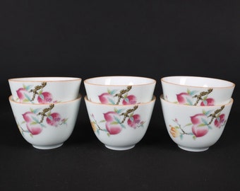 Un juego de tazas pequeñas antiguas chinas de color rosa con estampado de longevidad.