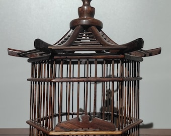 Gammalt hänge i bur med gräshoppa i rosenträ