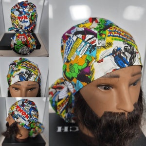 May include: A white surgical scrub hat with a colorful comic book print featuring Marvel superheroes like Hulk, Captain America, and Thor. The print includes speech bubbles and comic book panels.