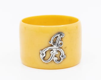 Żółty pierścień na serwetki w stylu vintage z ozdobnym monogramem w kształcie litery „P”, „L” lub „B”