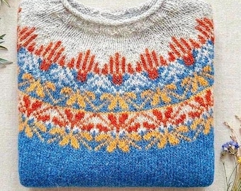 May include: A knitted sweater featuring a round neckline and a yoke with a multi-colored geometric pattern. The design incorporates shades of light gray, bright orange, yellow, and blue, transitioning into a solid blue body at the lower section.