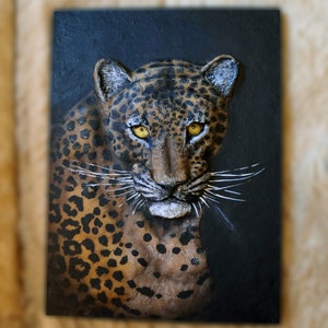 Sculpture of a leopard on the wall. Leopard painting. Artistic tiles. Wall sculpture of a leopard with relief.