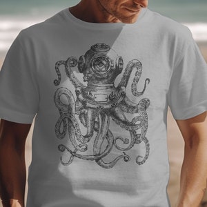 Peut inclure: Un t-shirt gris avec une illustration en noir et blanc d'une pieuvre portant un casque de plongée.