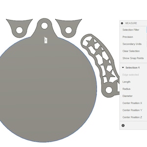 May include: A gray circle with a diameter of 8.50 inches, surrounded by a blue outline. The circle is part of a larger design that includes three smaller circles and a star-shaped design. The image also includes a measurement tool with details about the circle's dimensions.