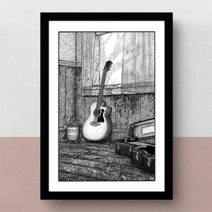 Op de afbeelding: Zwart-wit ingelijste prent van een gitaar die tegen een houten muur leunt. Een vintage koffer en een kleine plant in een pot staan op de voorgrond. Het kunstwerk is een gedetailleerde pen- en inkttekening.