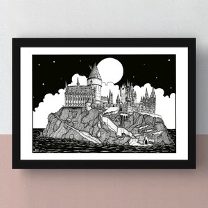 May include: Black and white art print of a castle on a rocky island under a starry night sky. The castle has multiple towers and is surrounded by water. The print is in a black frame.