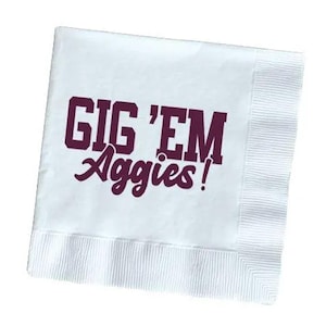 May include: White paper napkin with the words "Gig 'Em Aggies!" printed in purple.