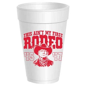 May include: A white foam cup with a red graphic that reads "THIS AIN'T MY FIRST RODEO" and features a cowboy hat and a portrait. The numbers "45" and "47" are also printed on the cup.