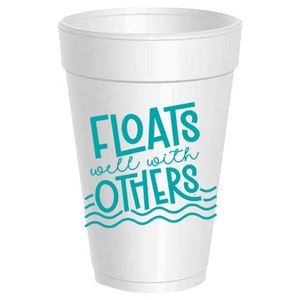 May include: A white foam cup with the words "FLOATS well with OTHERS" in teal lettering. The design includes teal wave graphics at the bottom of the text. The cup is a classic disposable beverage container.
