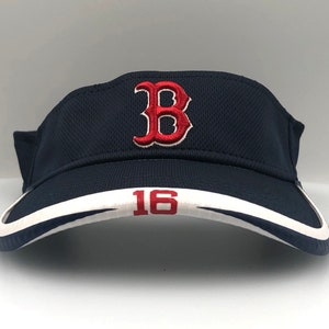 May include: A navy blue visor with a white and navy trim. The visor features the red embroidered letter "B" and the number "16". The visor is designed to shield the eyes from the sun.