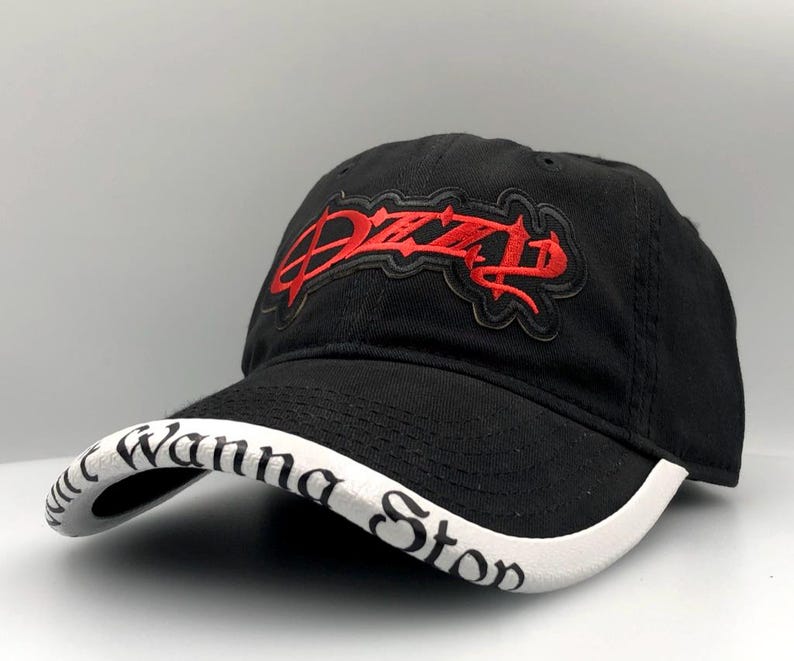 May include: Black baseball cap with a curved brim. The cap features red embroidered text that reads "Ozzy" on the front and "Wanna Stop" on the brim. The cap is made of a durable fabric and has a classic, adjustable design.