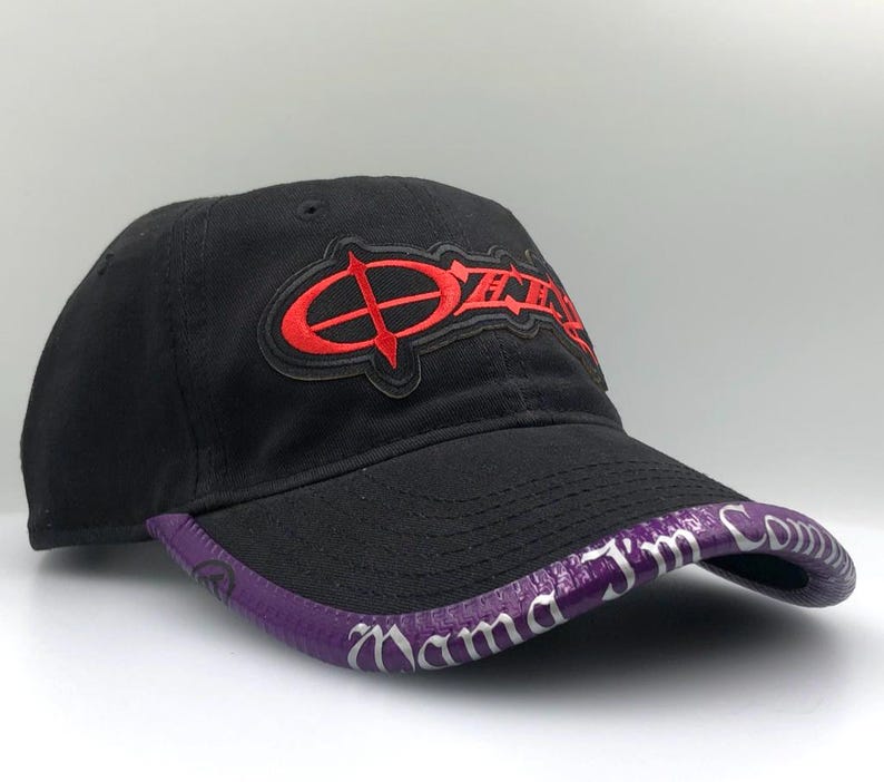 May include: Black baseball cap with a curved brim. The cap features a red logo on the front and a purple brim with white text. The cap is made of a soft material and has a curved brim.
