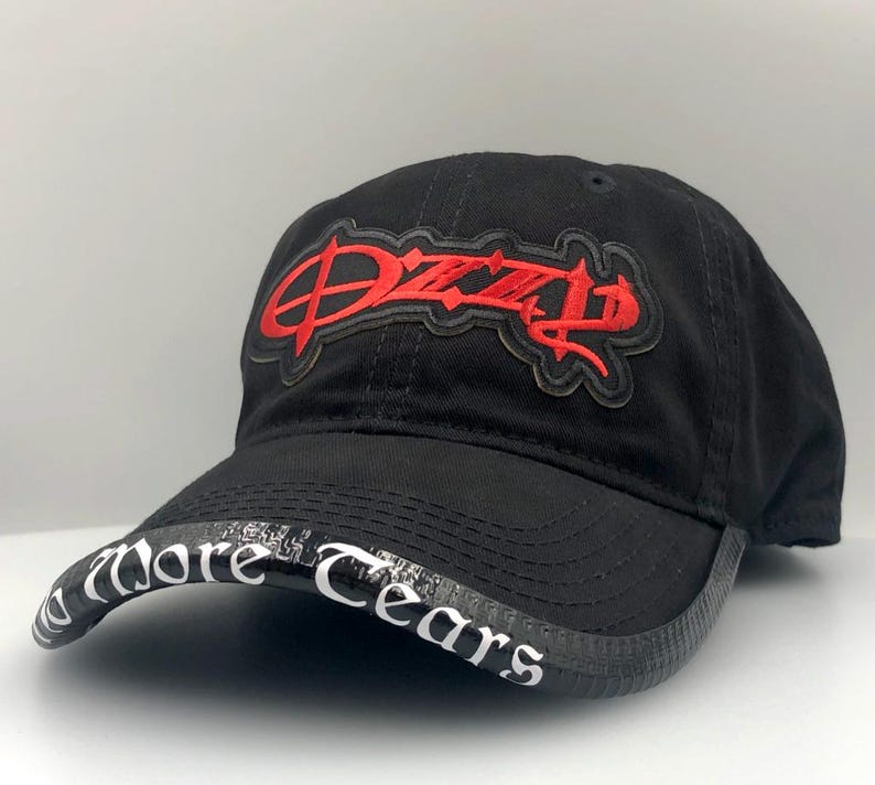 May include: Black baseball cap with the word "Dizzy" embroidered in red on the front. The brim features the words "More Tears" in white lettering. A stylish and casual accessory.