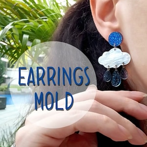 Puede incluir: Un par de pendientes de nube azul y blanca con detalles de gotas de lluvia. Los pendientes están hechos de resina y tienen un acabado brillante. El texto "EARRINGS MOLD" es visible en la imagen.