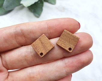 May include: Two small, square wooden tags with a hole in the center. The tags are a light brown color and have a natural wood grain.