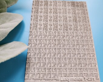 May include: A close-up of a beige textured surface with a repeating pattern of small squares. The surface has the text "Luxury molds T-231" printed in the bottom right corner.