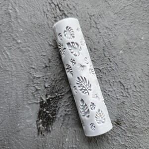 May include: A white rolling pin with a leaf pattern design. The rolling pin is made of a durable material and is perfect for creating decorative patterns in fondant, clay, or dough.