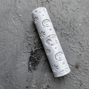 May include: A grey rolling pin with a snowflake and wreath design.