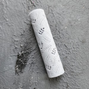 May include: White rolling pin with a leaf pattern embossed on the surface.