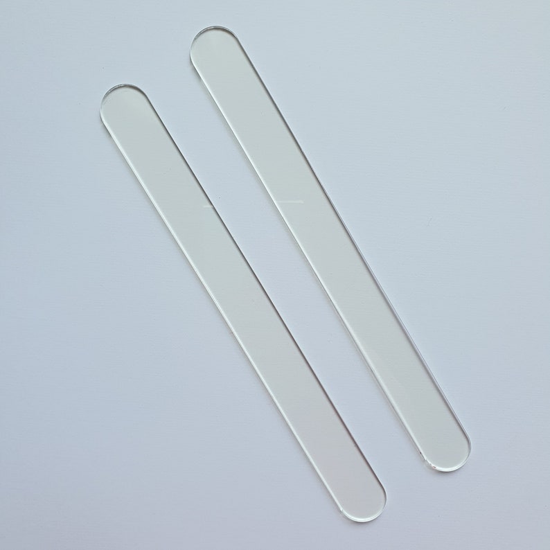 Puede incluir: Dos varillas para remover de acr&iacute;lico transparente, de forma rectangular y con extremos redondeados. Las varillas son transparentes y parecen estar hechas de un material liso y pulido. Est&aacute;n colocadas en diagonal sobre un fondo blanco.