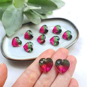 Pode incluir: Conjunto de contas de vidro em forma de coração verde e rosa. As contas têm um efeito degradê de cor, com o verde que se desvanece em rosa.