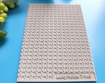 May include: A gray silicone mold with a repeating geometric pattern. The mold is labeled "Luxymolds T-149".