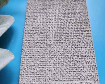 May include: A gray textured silicone mold for crafting. The mold has a rough, uneven surface and the text "Luxy molds T-261" is printed on the bottom right corner.