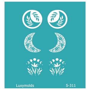 Pode incluir: Uma folha de estêncil branca com seis designs de lua diferentes. Os designs incluem uma lua crescente com folhas, uma lua crescente com padrões florais e uma lua crescente com uma flor e estrelas. A folha de estêncil é etiquetada "Luxymolds S-311".