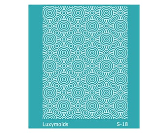 May include: A teal stencil featuring a repeating pattern of white concentric circles. The rectangular stencil has the text "Luxymolds" and "S-18" printed on it.
