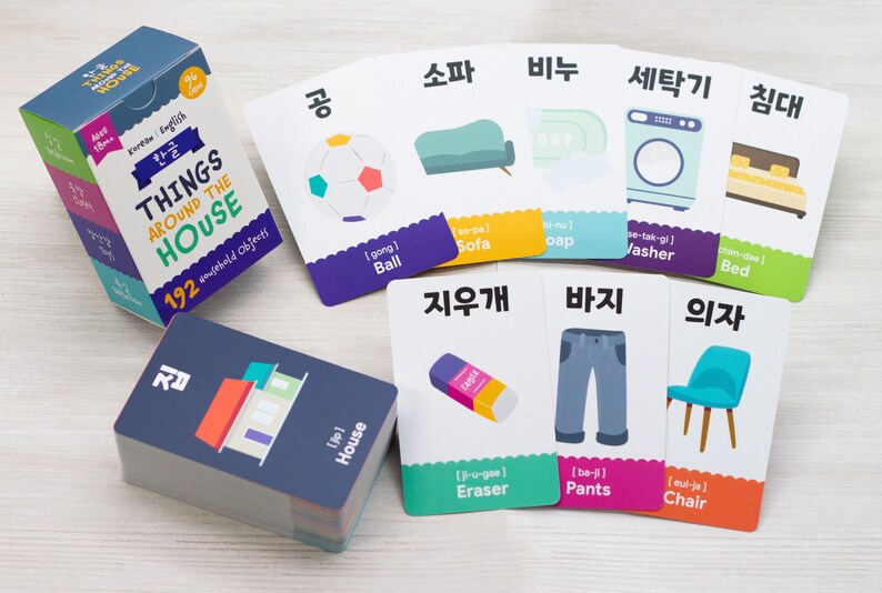 May include: A set of colorful flashcards with Korean and English words for household objects. The cards feature illustrations of a ball, sofa, soap, washing machine, bed, eraser, pants, and chair. The cards are part of a larger set of 192 cards.