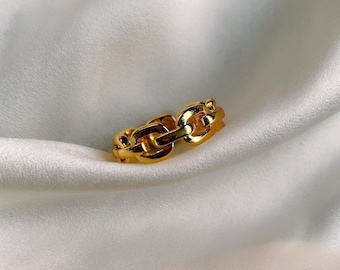 May include: A gold chain link ring. The ring is made of thick, chunky links and has a polished finish.