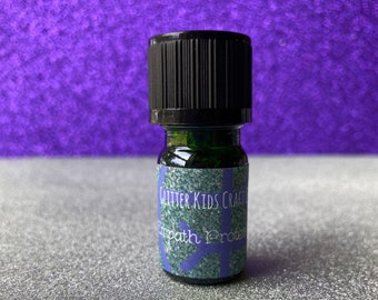 May include: A small green glass bottle with a black lid. The bottle has a label that says "Glitter Kids Craft Empath Protection".