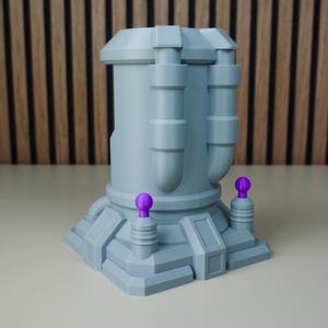Pode incluir: Estrutura cinza claro com apar&ecirc;ncia futurista, com corpo cil&iacute;ndrico e base em camadas. Dois detalhes roxos e esf&eacute;ricos assentam sobre a base. Dois tubos cil&iacute;ndricos se estendem da parte superior. O objeto &eacute; provavelmente uma pe&ccedil;a decorativa ou um modelo.