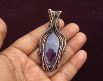 May include: A purple amethyst gemstone wrapped in copper wire, creating a pendant.
