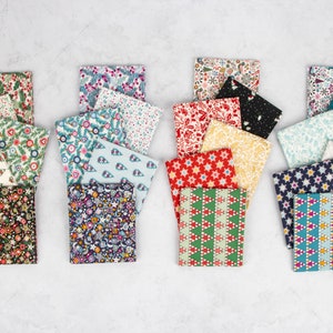 May include: A collection of 20 fabric squares featuring a variety of Christmas-themed patterns. The squares are arranged in four rows of five, with each row showcasing a different colour scheme. The patterns include stars, snowflakes, trees, and other festive designs. The fabrics are a blend of cotton and linen.