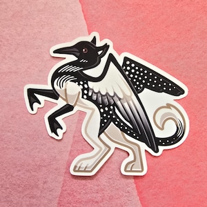 May include: A sticker featuring a stylized creature with a bird-like head and wings, and the body of a quadruped. The design is primarily black and white with tan and gray accents. The background is a solid pink color.