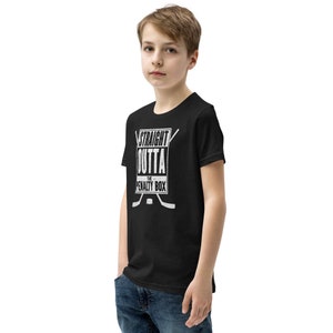 May include: Black youth t-shirt with a white graphic that says "Straight Outta The Penalty Box" with hockey sticks and a puck.